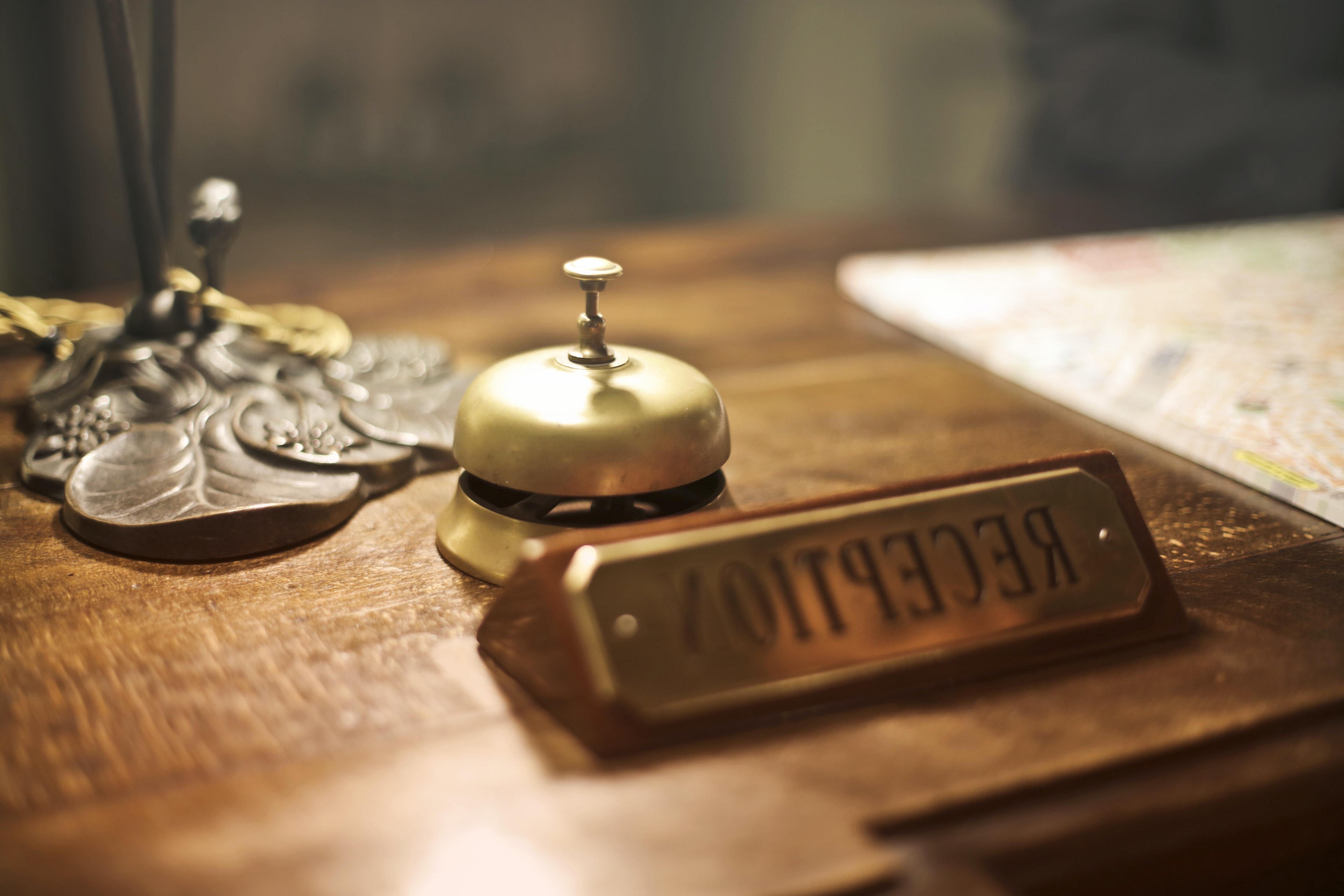 Hotel reception desk with bell and label.