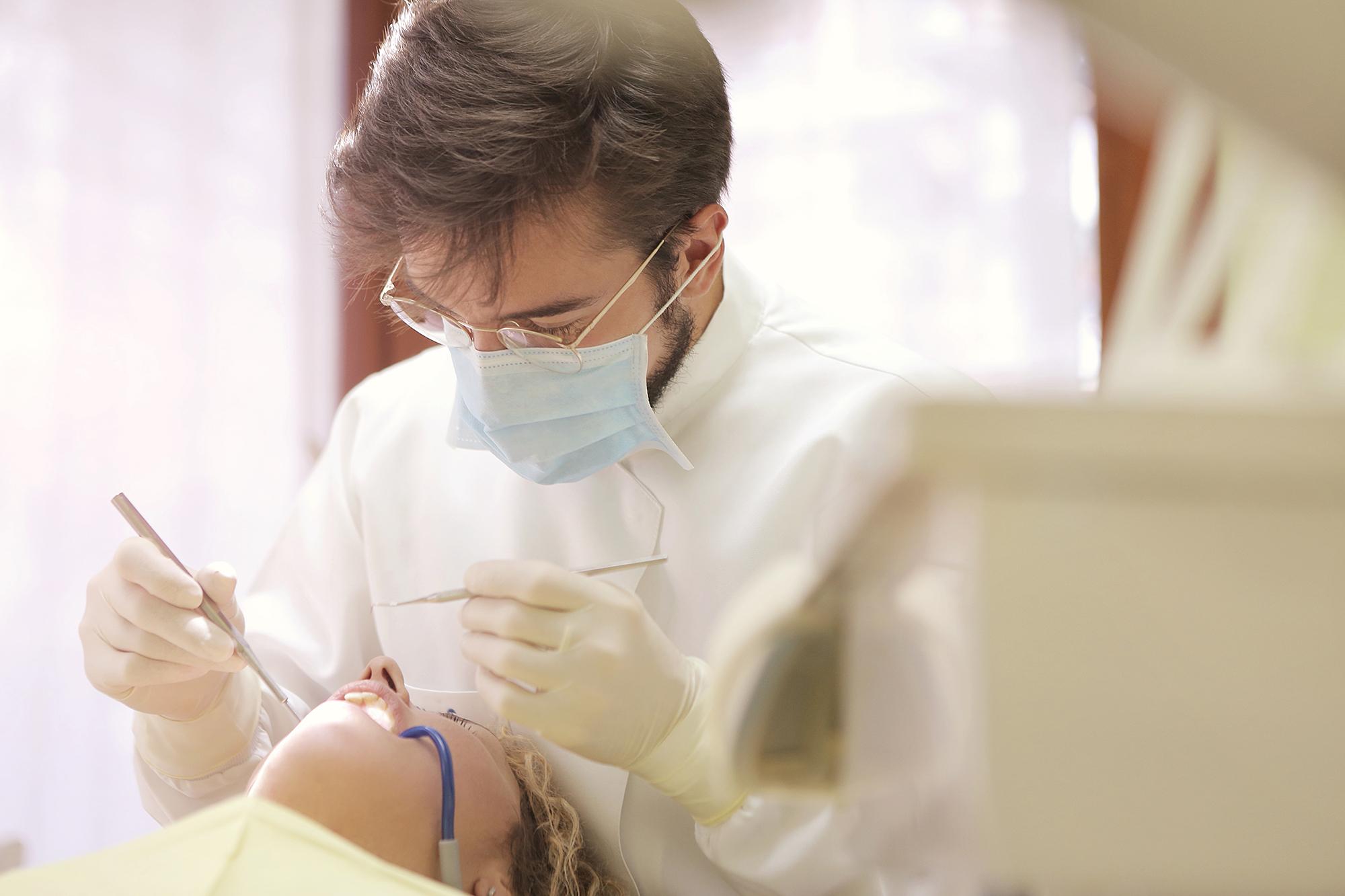 Dentist cleaning a person's teeth.